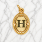 Gold pendant with letter 'H' on a marble background 19.2K Portuguese Gold | Oval Initial Charms