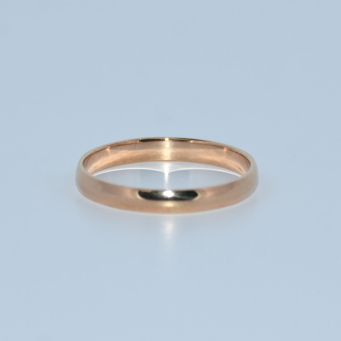 Rose gold ring on a light blue background