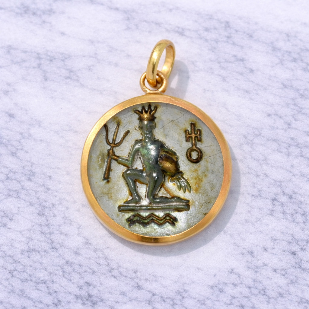 19.2K Portuguese Gold pendant with a detailed aquarius design on a textured white background