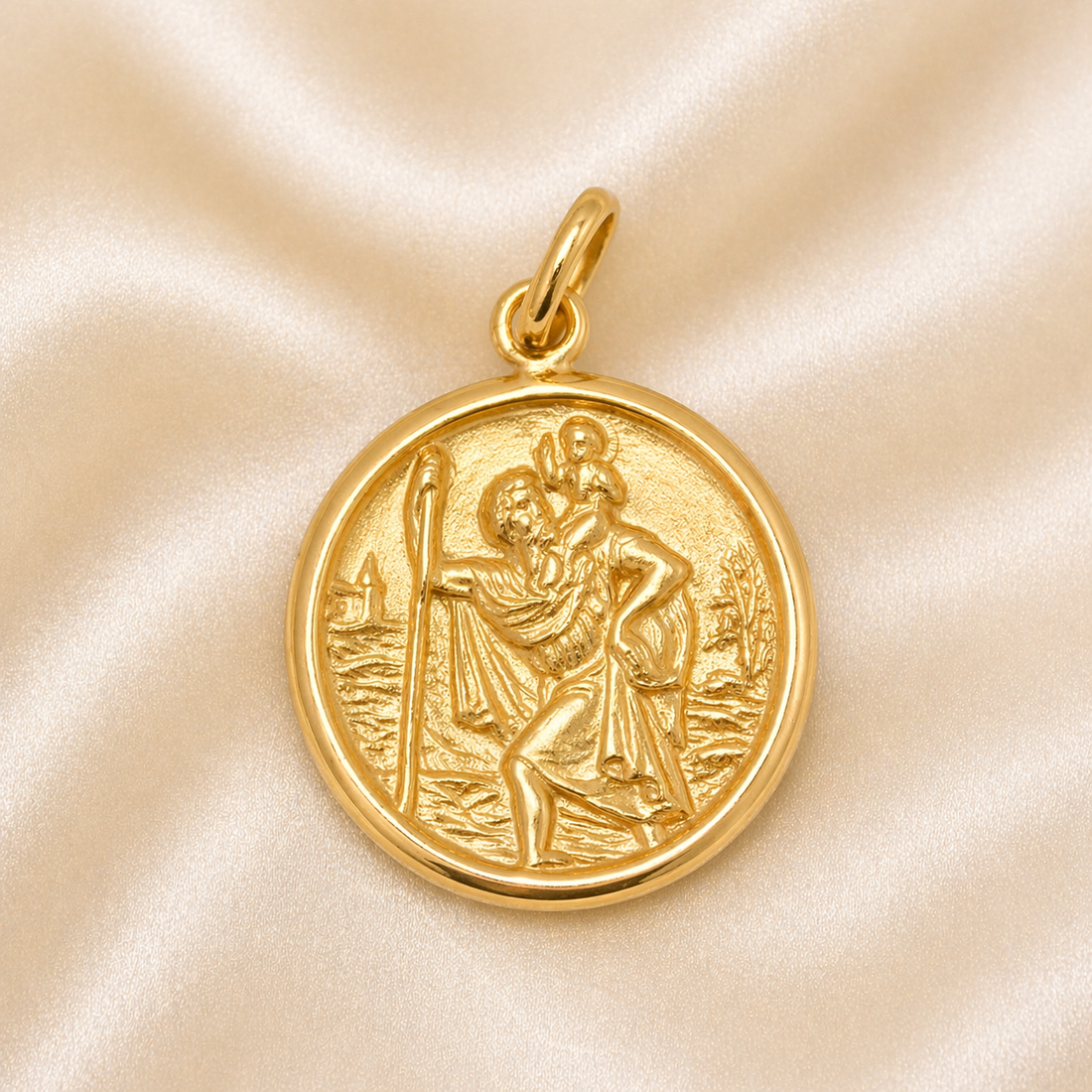 Gold pendant with religious design on a beige fabric background