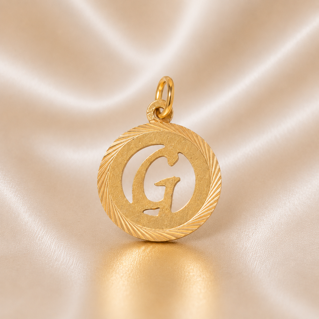 Gold pendant with letter 'G' on a beige satin background 19.2K Portuguese Gold | Round Cutout Initial Charms 