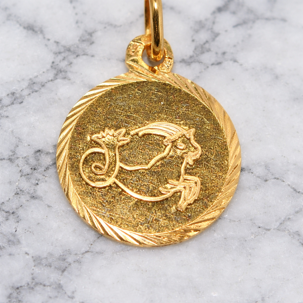 19.2K Portuguese Gold Capricorn Zodiac pendant on a marble background
