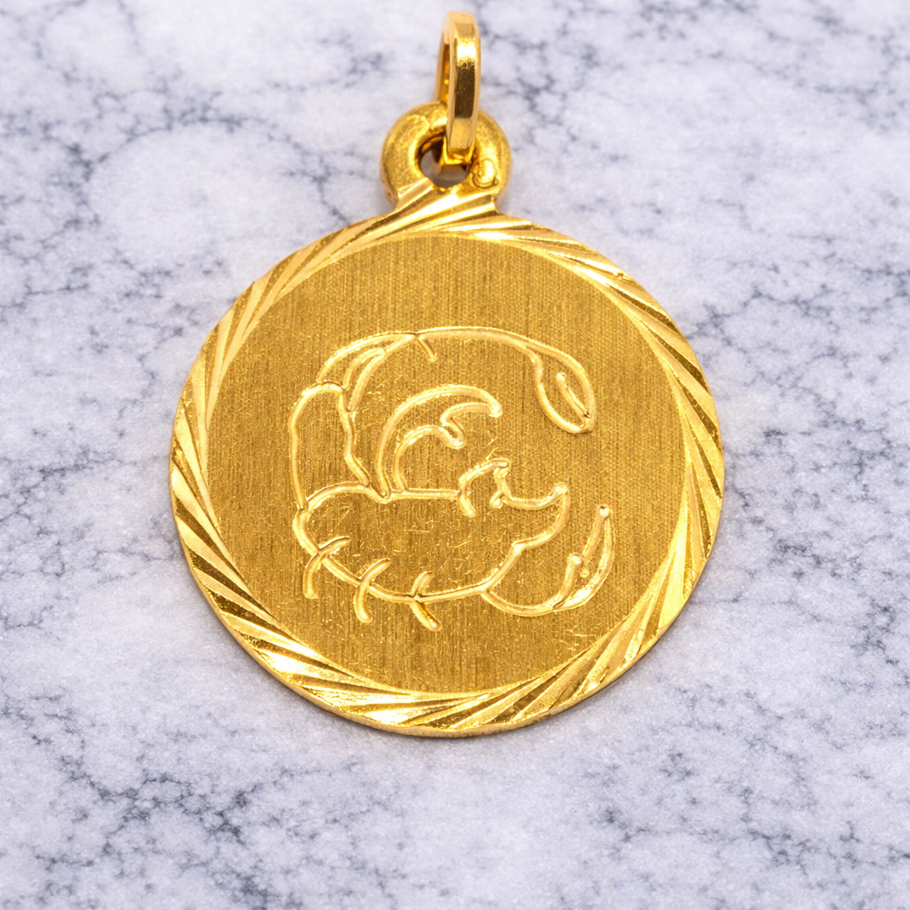 19.2K Portuguese Gold Scorpio Zodiac pendant with a design on a marble background