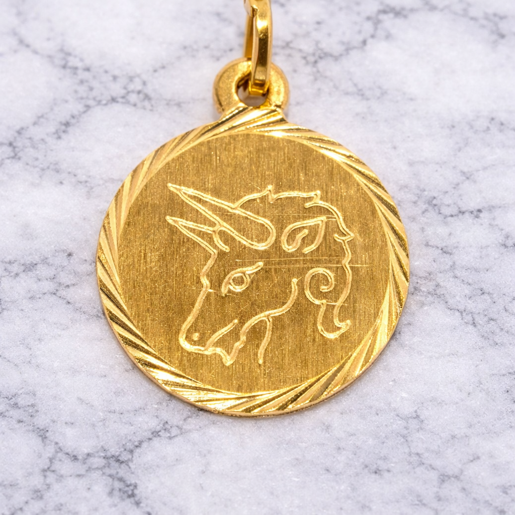 19.2K Portuguese Gold Taurus Zodiac unicorn pendant on a marble background