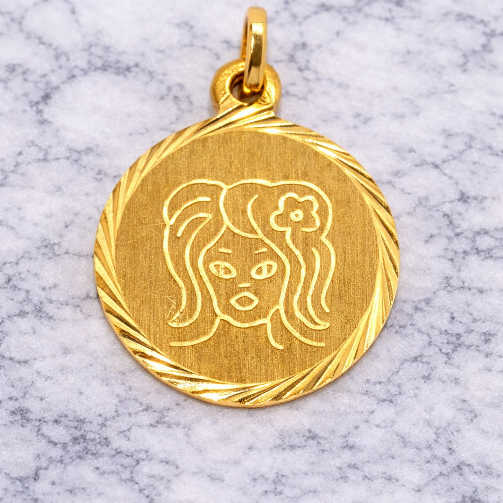19.2K Portuguese Gold Virgo Zodiac pendant with engraved face on a marble surface