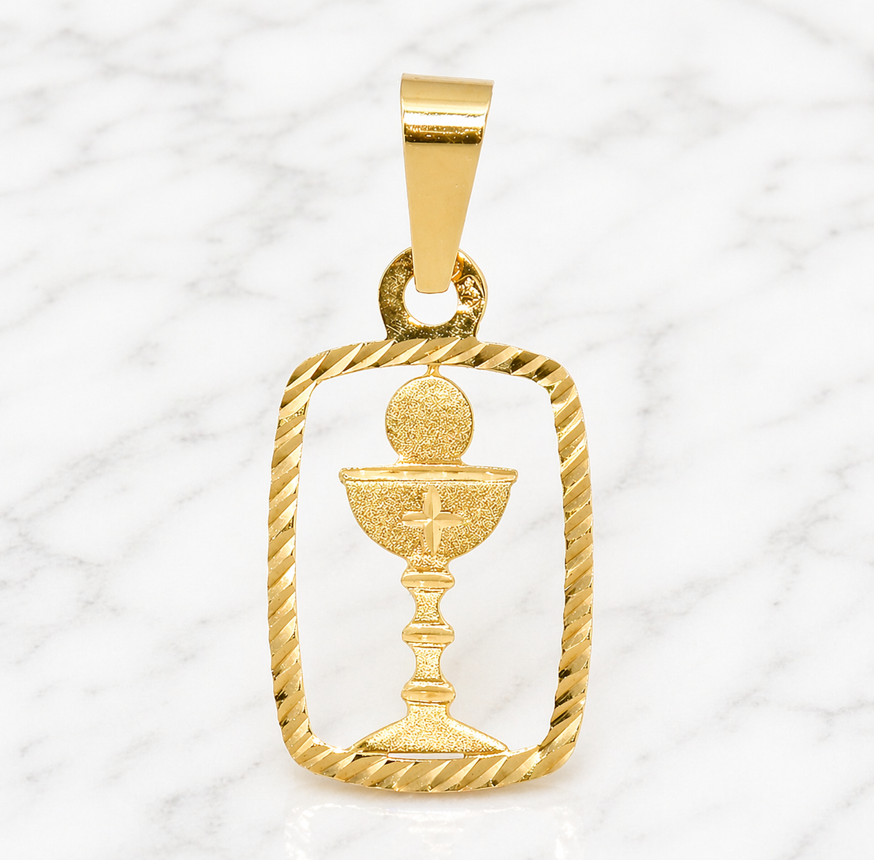 19.2K Portuguese Gold | Small Cut Out Communion Charm Gold Pendant with a Detailed Design on a marble background