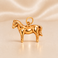 Gold horse-shaped pendant on a beige satin background 19.2K Portuguese Gold | Small Horse Charm