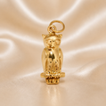Gold owl pendant on a beige satin background 19.2K Portuguese Gold | Small Owl Charm