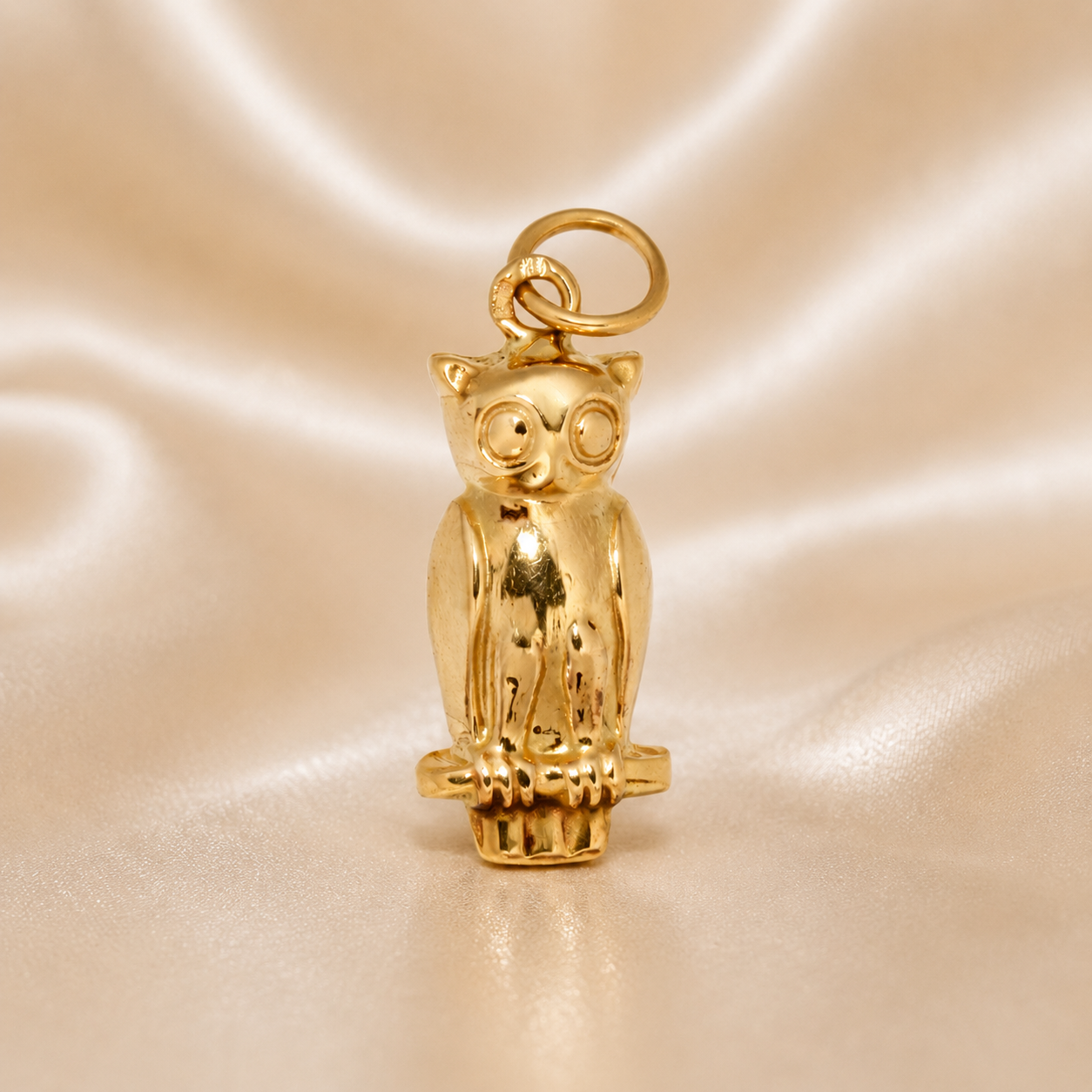 Gold owl pendant on a beige satin background 19.2K Portuguese Gold | Small Owl Charm