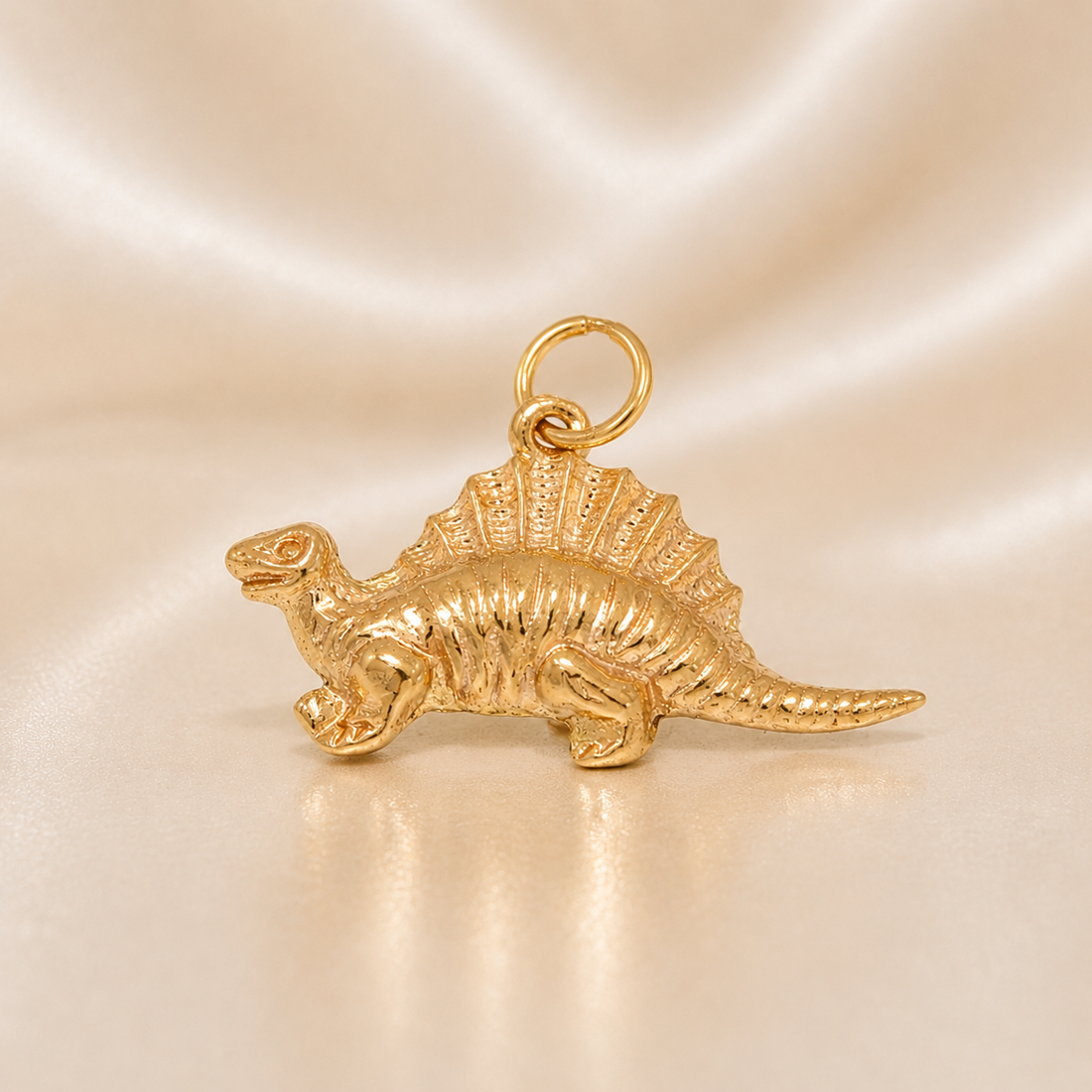 Gold dinosaur charm on a beige background 19.2K Portuguese Gold | Spinosaurus Dinosaur Charm
