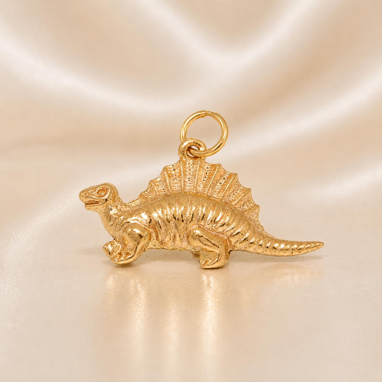 Gold dinosaur charm on a beige background 19.2K Portuguese Gold | Spinosaurus Dinosaur Charm