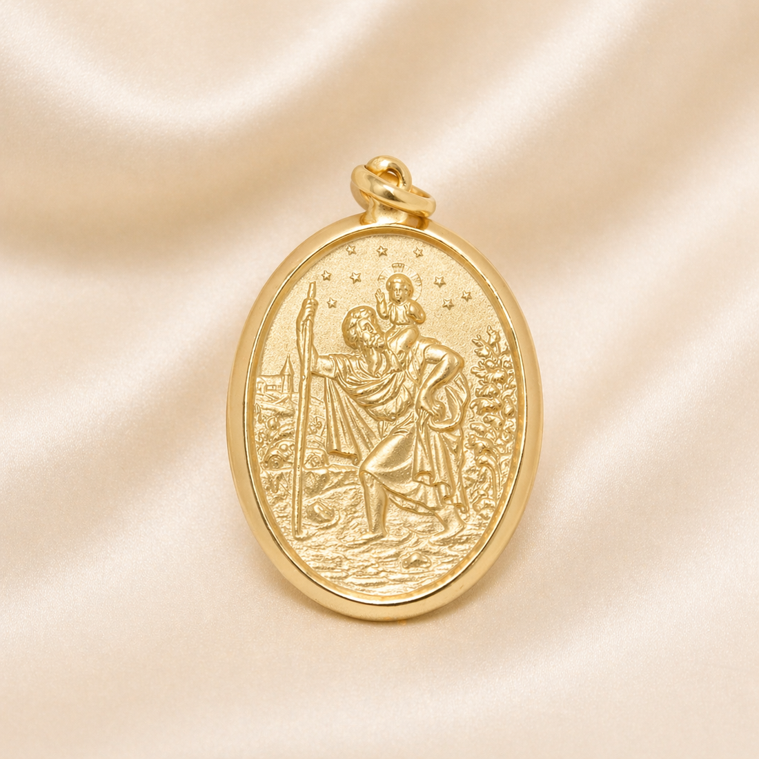 Gold pendant with religious design on a beige satin background
