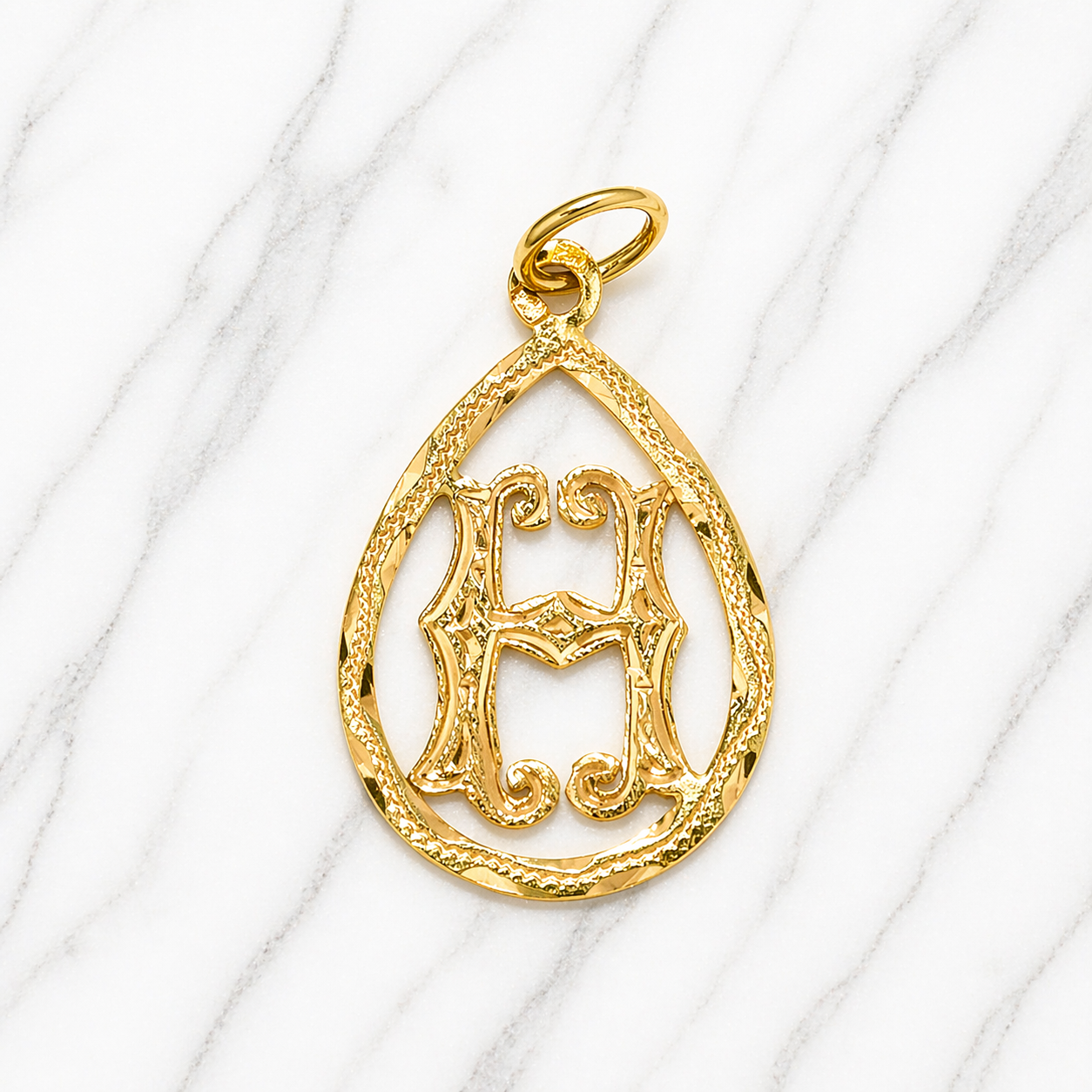 Gold pendant with intricate design on a white background 19.2K Portuguese Gold | Tear Drop Letters Letter H 