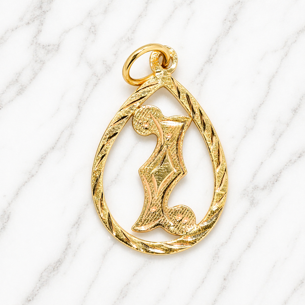 Gold pendant with intricate design on a white marble background 19.2K Portuguese Gold | Tear Drop Letters Letter I 