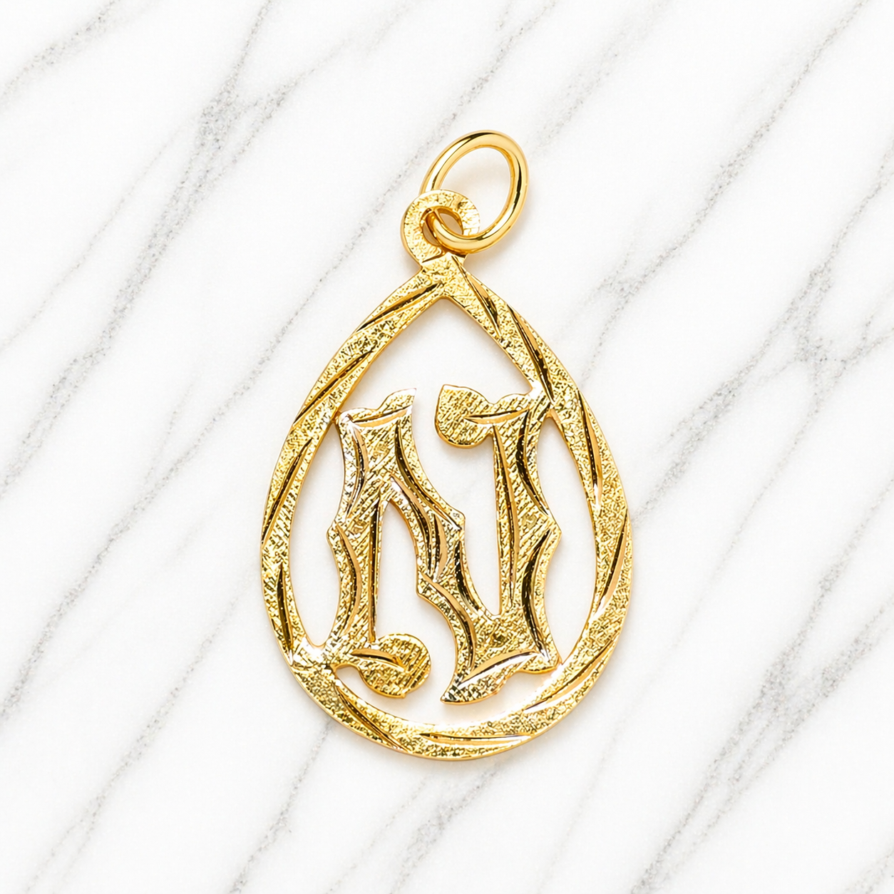 Gold pendant with a letter 'N' design on a white marble surface 19.2K Portuguese Gold | Tear Drop Letters