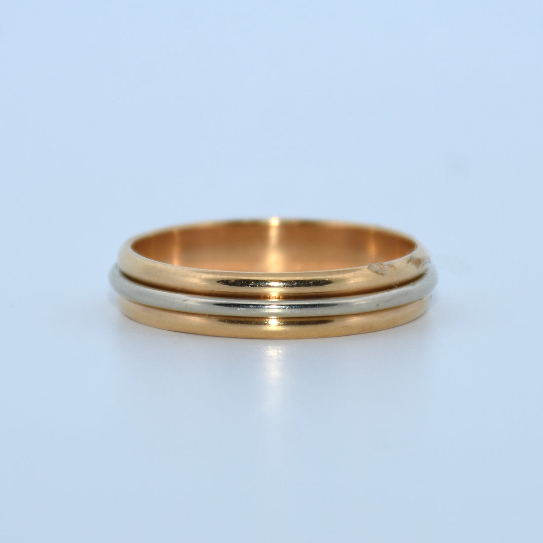Gold and silver ring on a light blue background