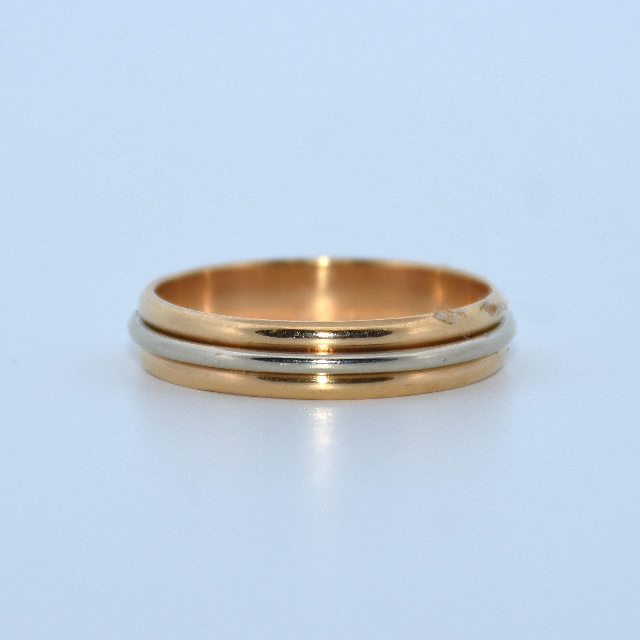 Gold and silver ring on a light blue background