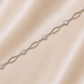 Silver bracelet with clear stones on a beige fabric background19.2K Portuguese Gold | WG Oval Link & CZ Bracelet