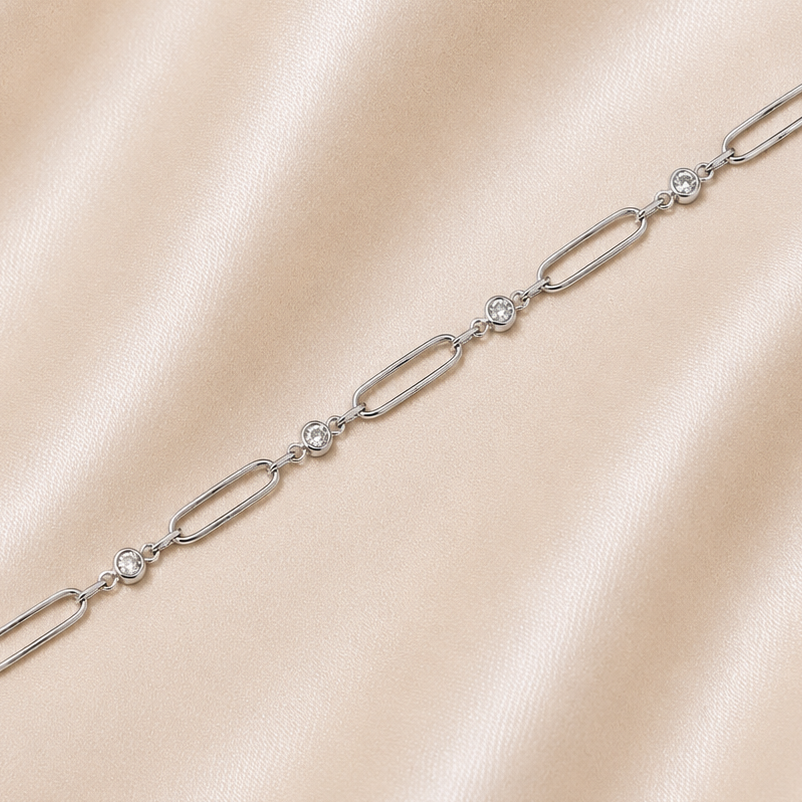 Silver bracelet with diamond accents on a beige satin background 19.2K Portuguese Gold | WG Thin Paperclip & CZ Bracelet
