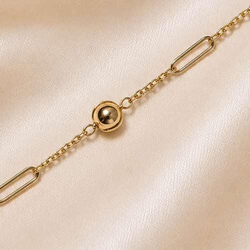 Gold bracelet on a soft pink satin background 19.2K Portuguese Gold | YG Dainty Ball & Thin Paperclip Bracelet 