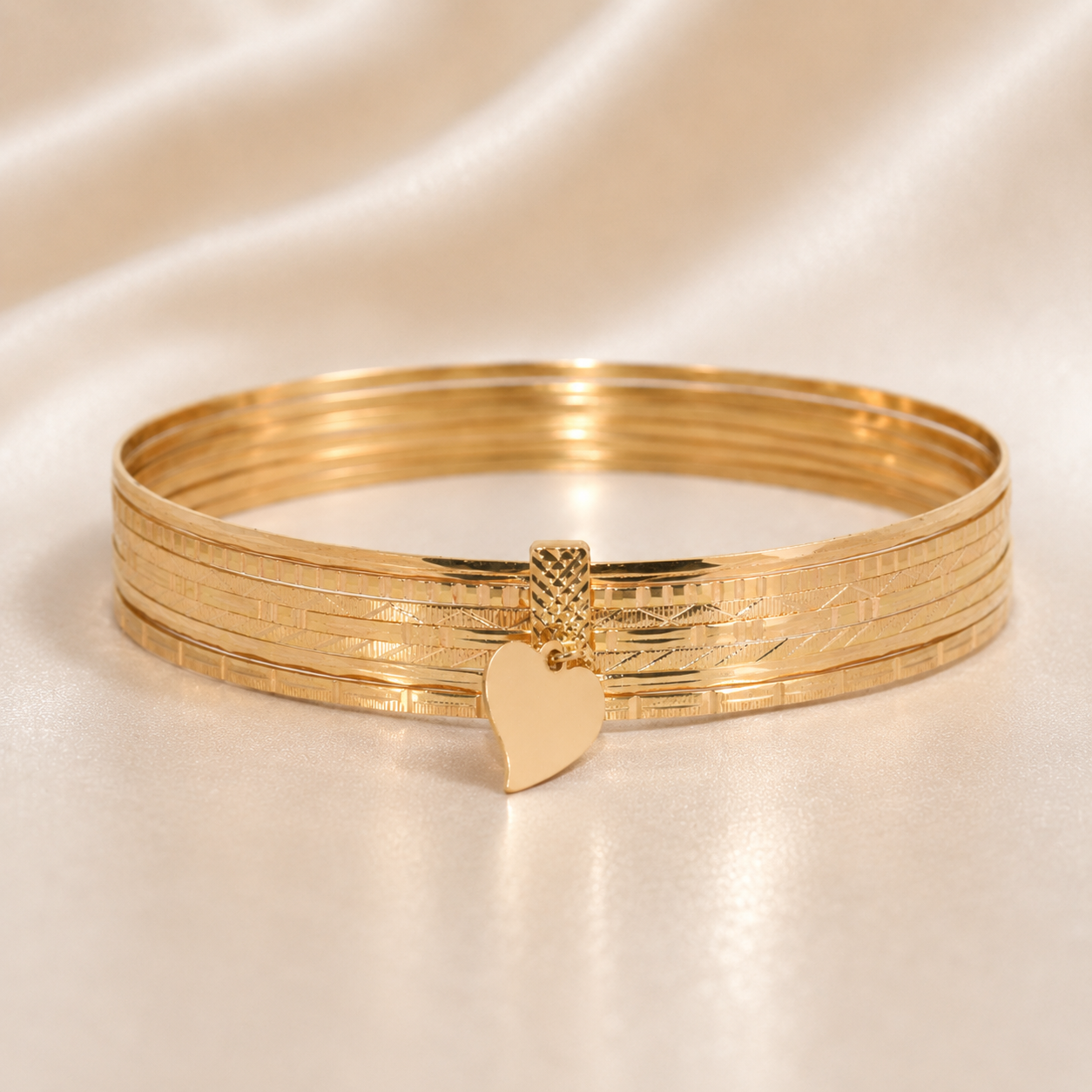 Gold bracelet with heart charm on a beige satin background 19.2K Portuguese Gold | 7 Band Bracelet Bangle with Dangle Heart
