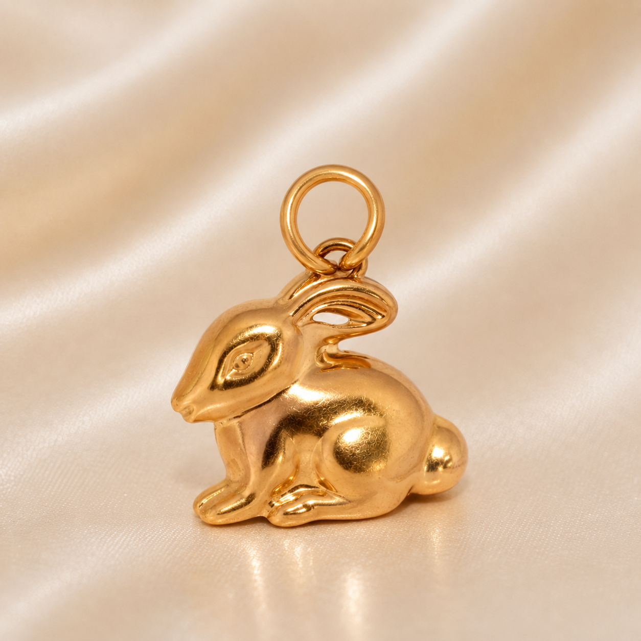 Gold rabbit-shaped pendant o n a beige satin background 19.2K Portuguese Gold | Rabbit Charm