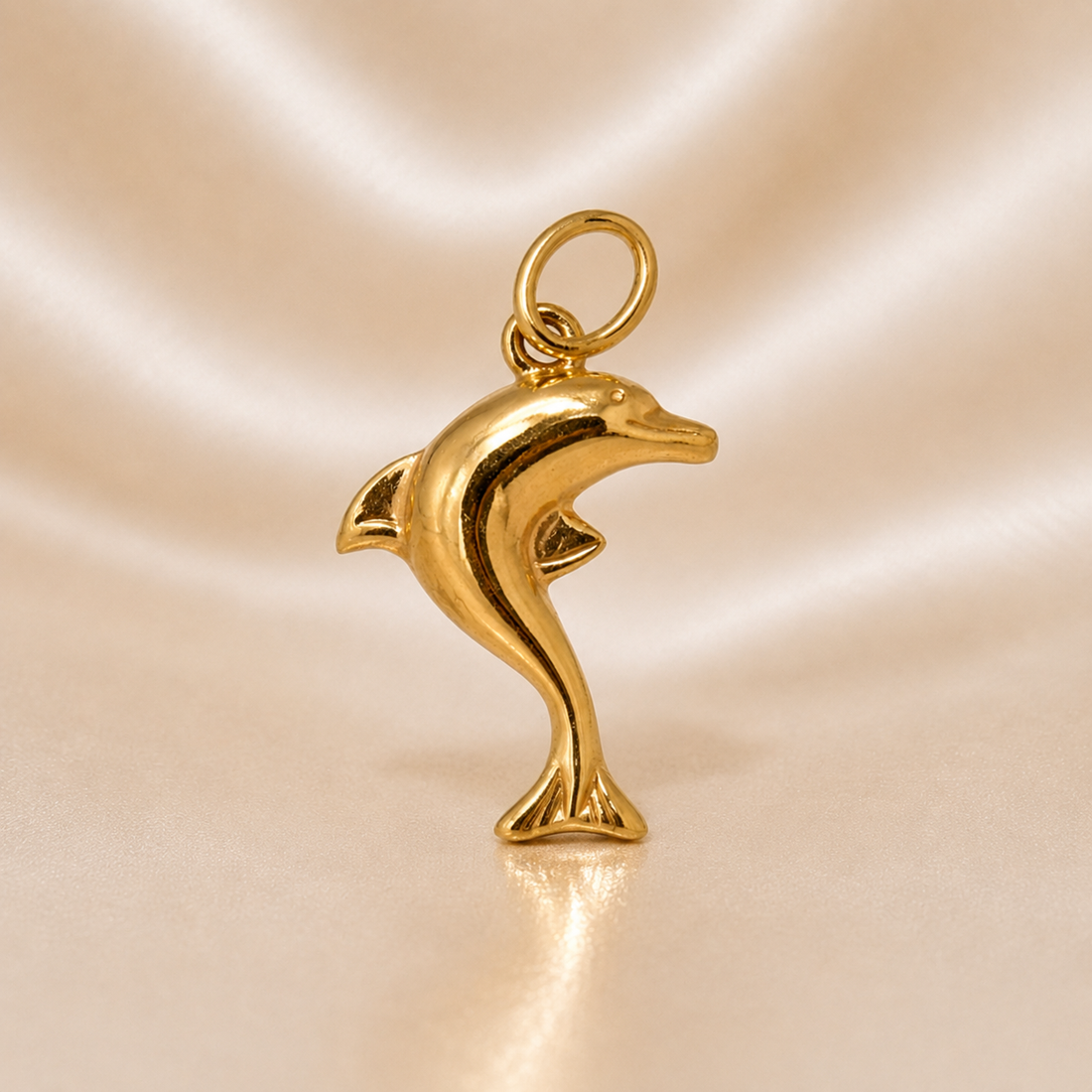 Gold dolphin pendant on a reflective gold background 19.2K Portuguese Gold | Small Dolphin Charm 