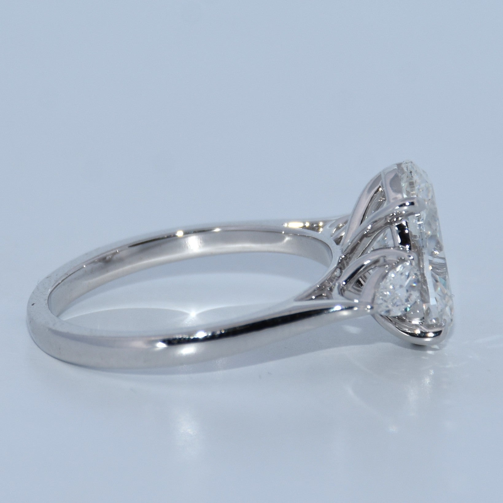 Silver ring with a diamond on a light gray background