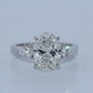 Diamond ring with a pear-shaped center stone on a light gray background