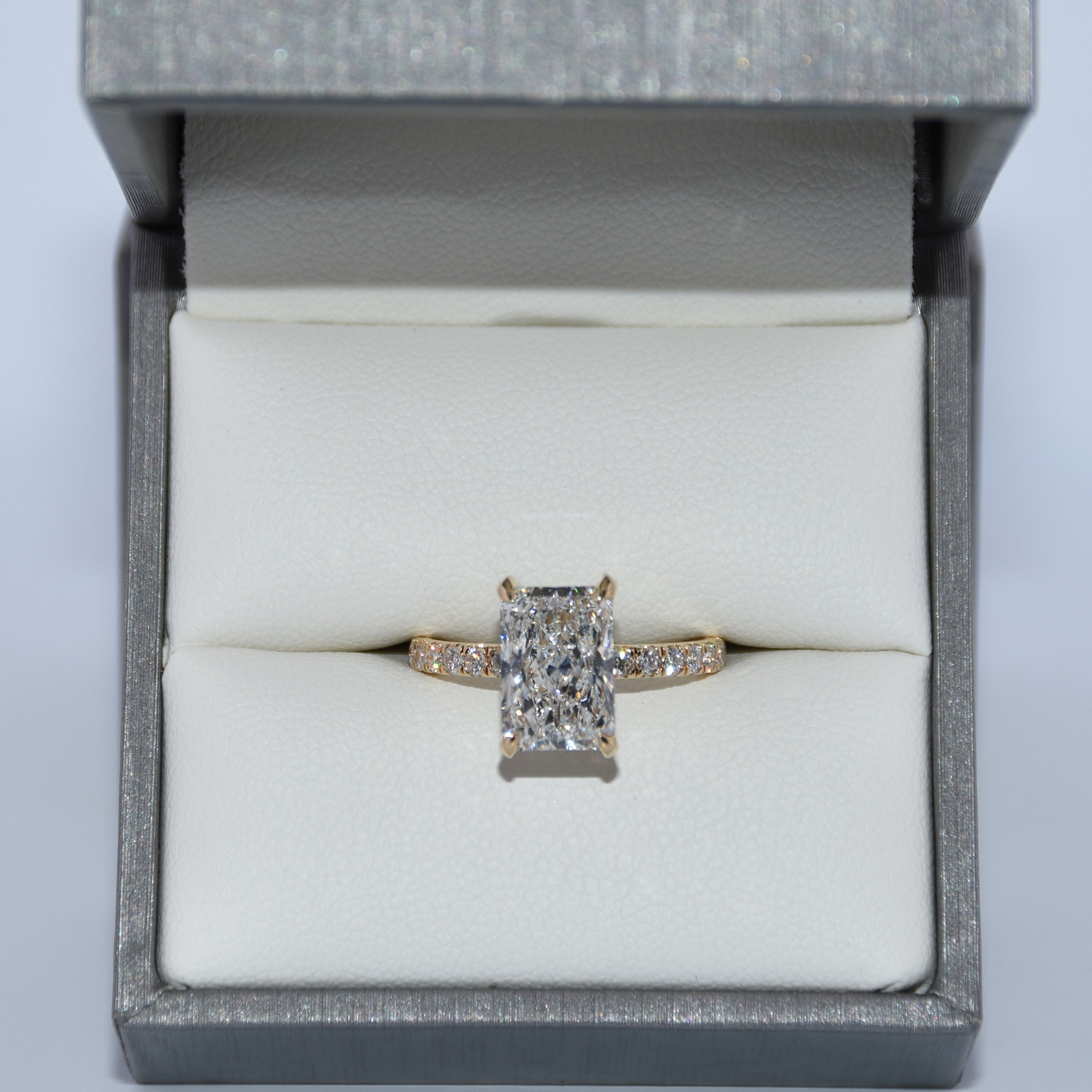 Diamond ring in a gray jewelry box on a light gray background