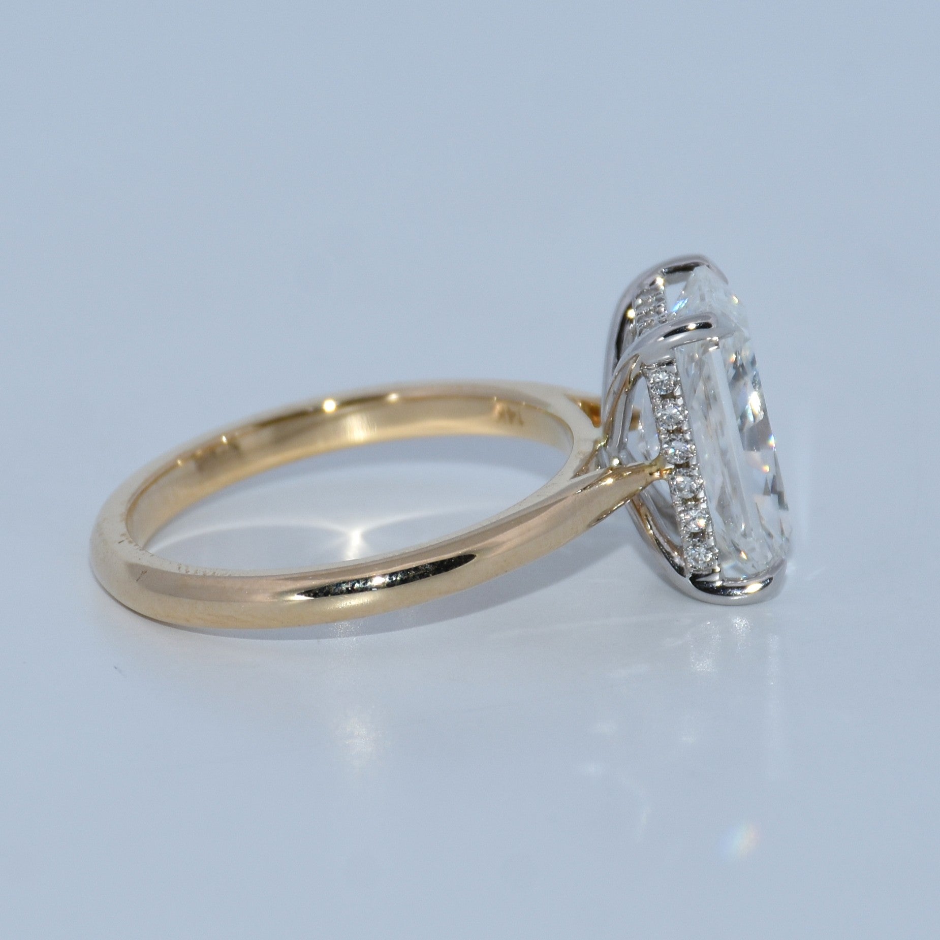 Gold ring with a diamond on a light gray background