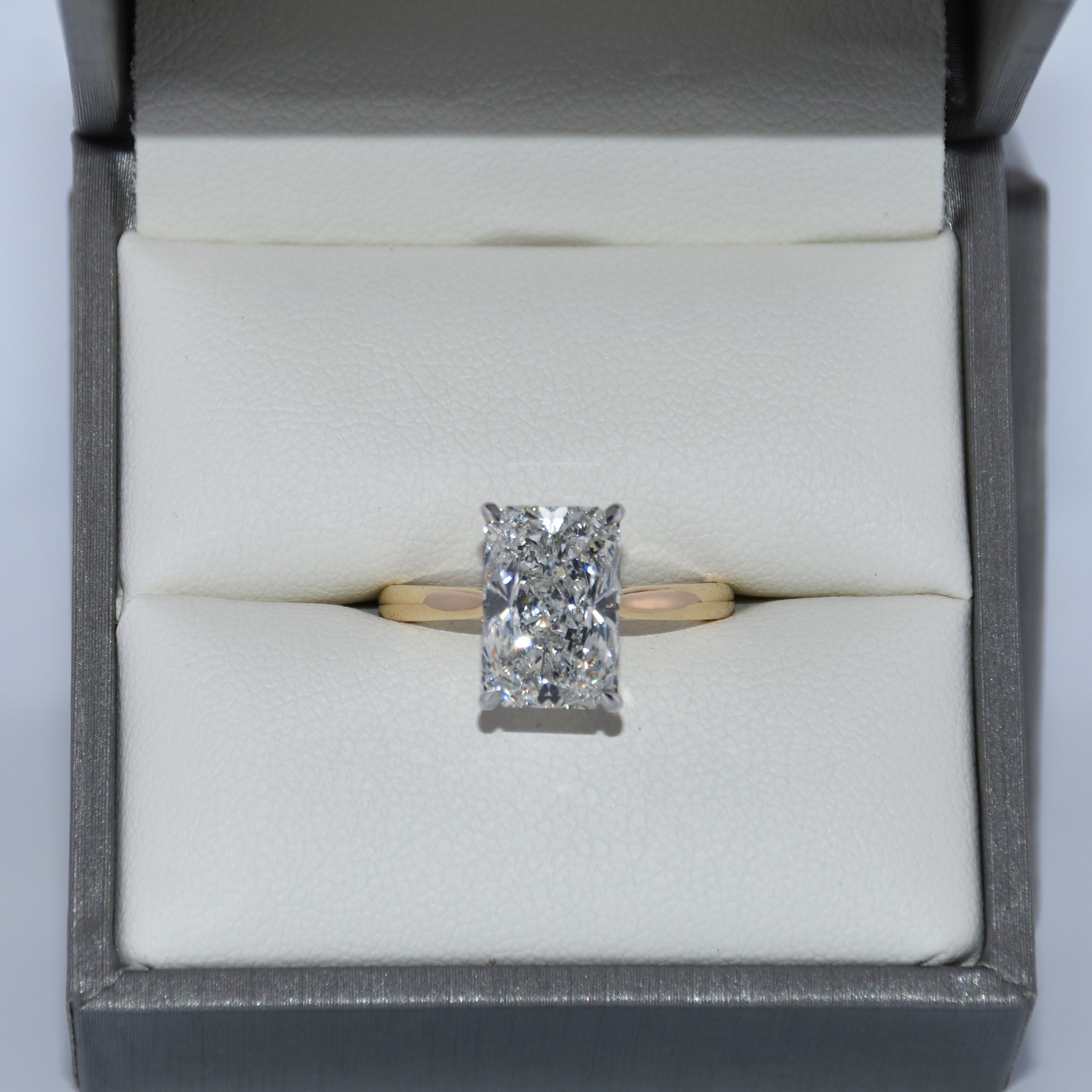 Diamond ring in a gray jewelry box on a white background