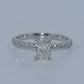 Diamond ring with a rectangular center stone on a light gray background
