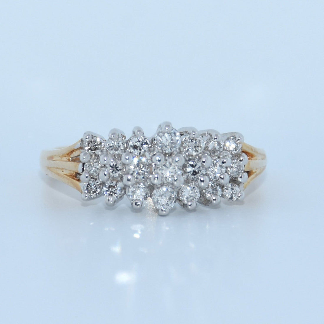 Diamond ring with a gold band on a light blue background