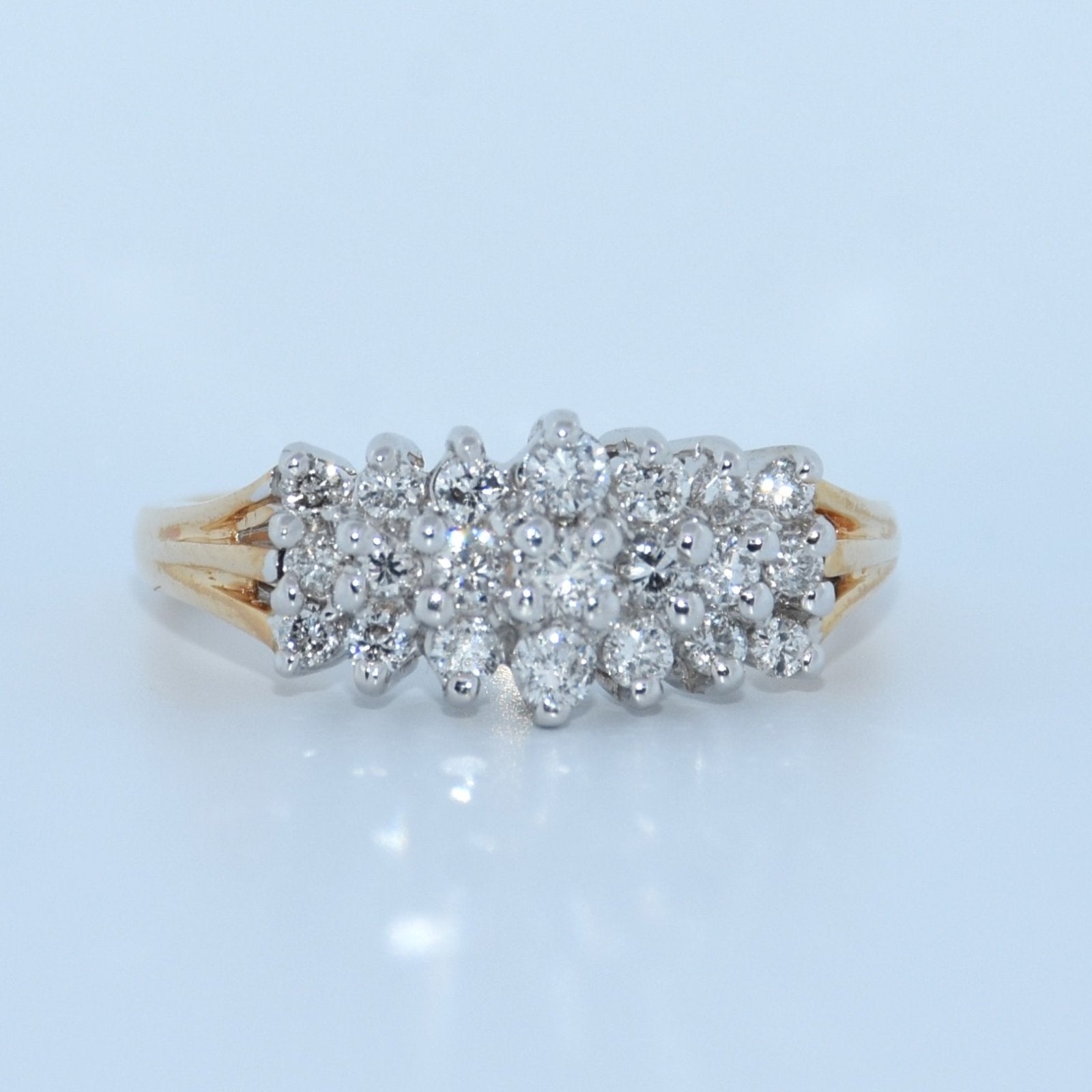 Diamond ring with a gold band on a light blue background