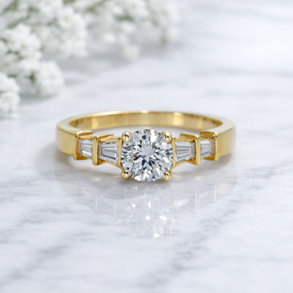 Gold ring with a large diamond and smaller baguette-cut diamonds on a light background