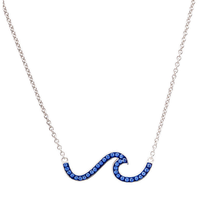 A silver chain necklace featuring a wave-shaped pendant paved with deep blue rhinestones, shown against a plain white background. Ocean | Deep Blue Sterling Silver Wave Necklace with Sapphire Blue crystals