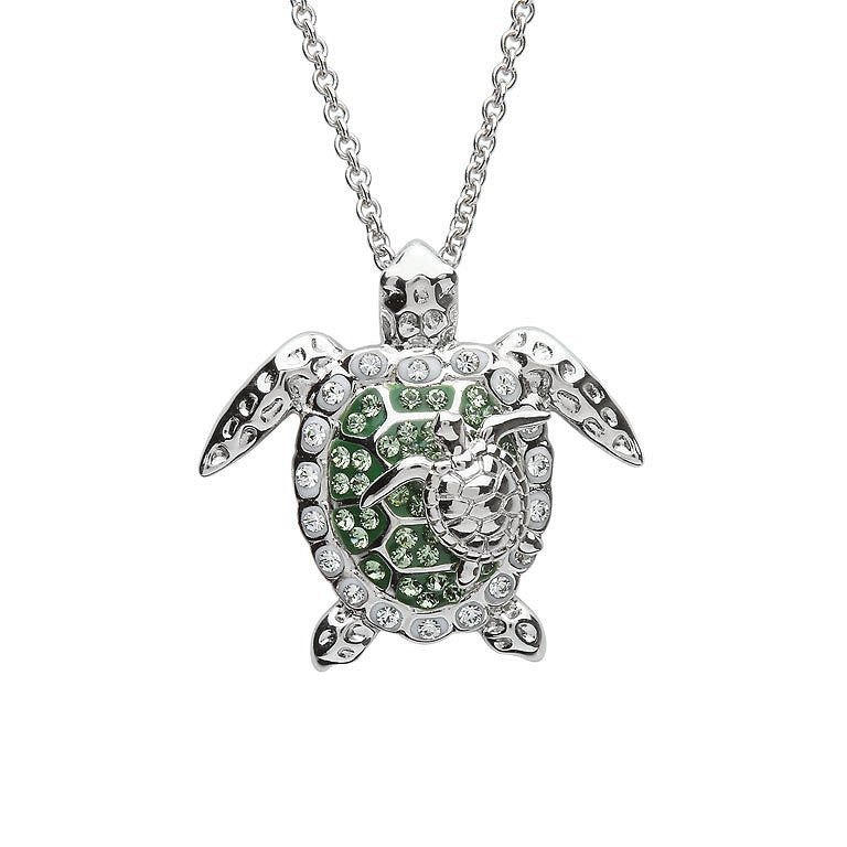 A silver sea turtle pendant necklace adorned with clear crystals and green enamel details, suspended from a silver chain against a plain white background. Ocean | Sterling Silver Green Swarovski Crystal Turtle and Baby Necklace