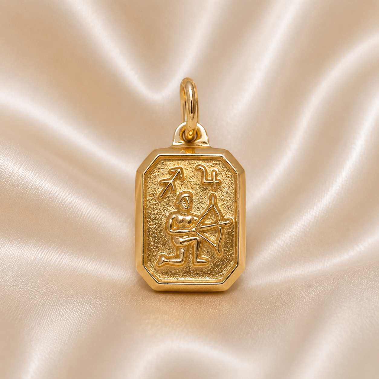 Gold pendant with astrological design on a beige satin background  19.2K Portuguese Gold | Rectangular Vintage Zodiac Pendants Sagittarius