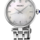 A Seiko women's watch featuring a silver stainless steel link bracelet, a round white mother-of-pearl dial, and crystal hour markers, shown on a clean white background.