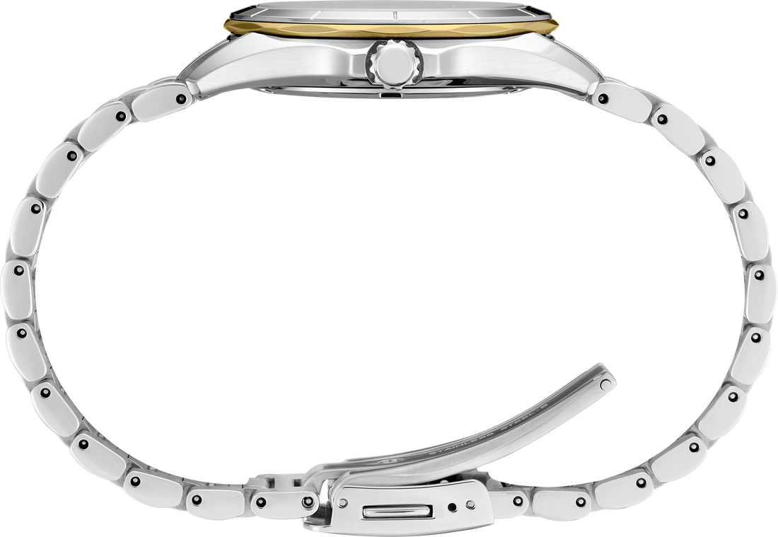Close-up of a silver watch with a gold face on a white background