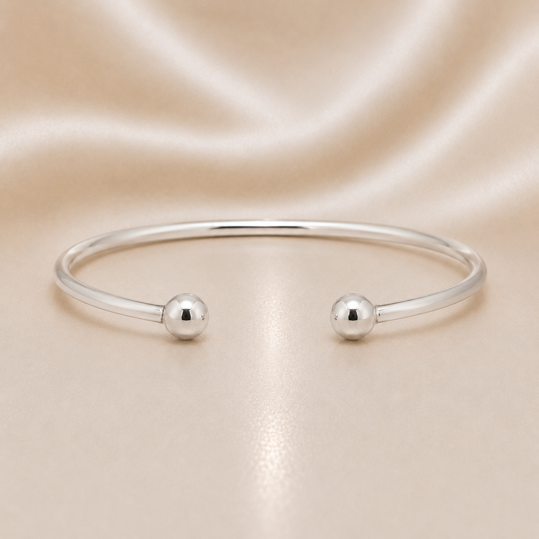 Silver bracelet with two spherical charms on a beige fabric background Sterling Silver | Ball Bangle Bracelet
