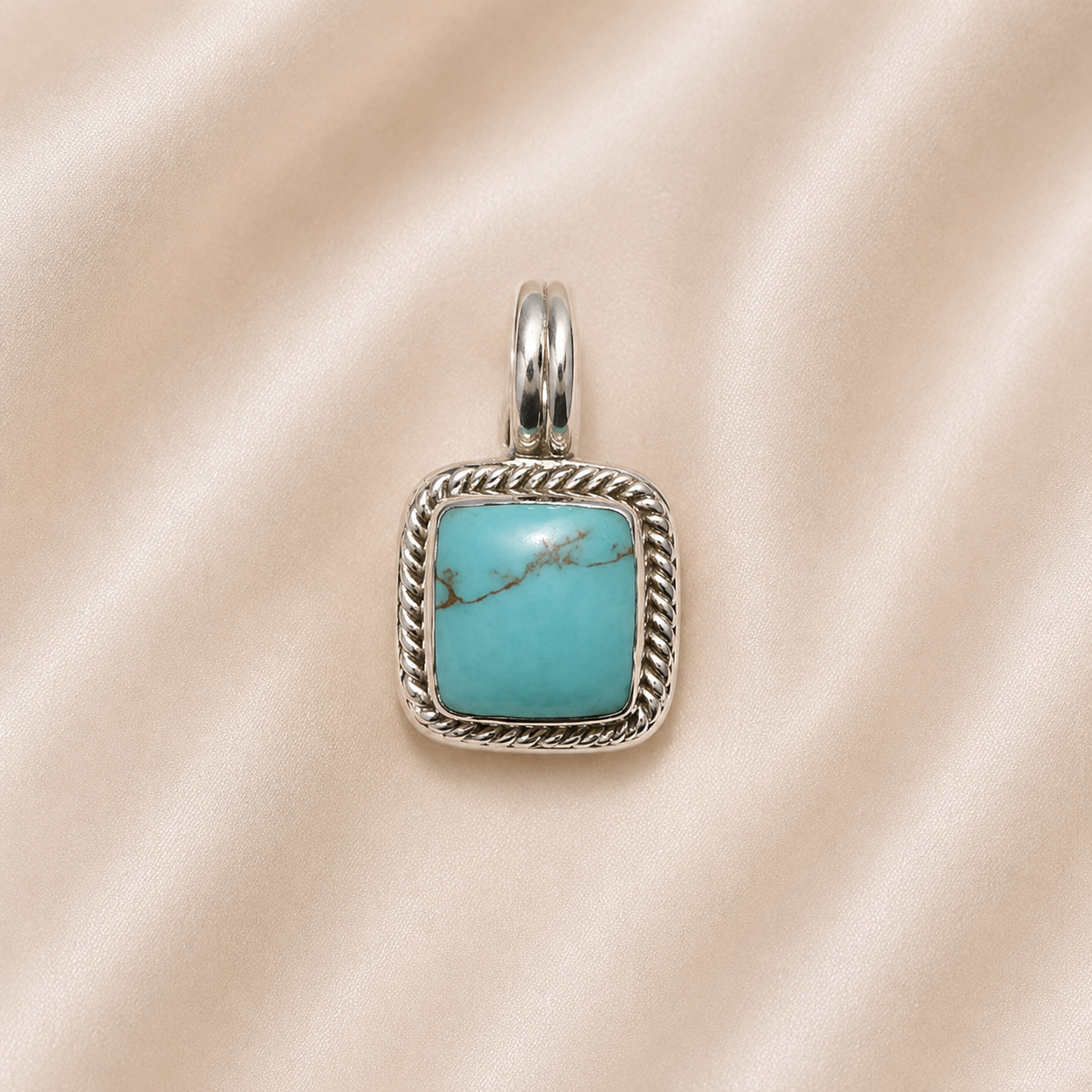 Turquoise stone pendant with silver frame on a beige fabric background Sterling Silver | Square Turquoise Pendant