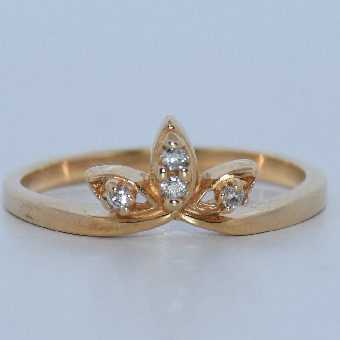Gold ring with diamond accents on a light gray background