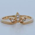 Gold ring with diamond accents on a light gray background