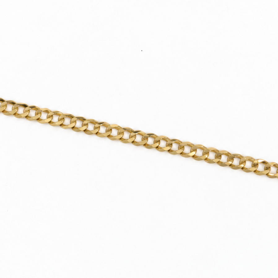 A close-up of a polished yellow gold curb chain running diagonally across a plain white background.