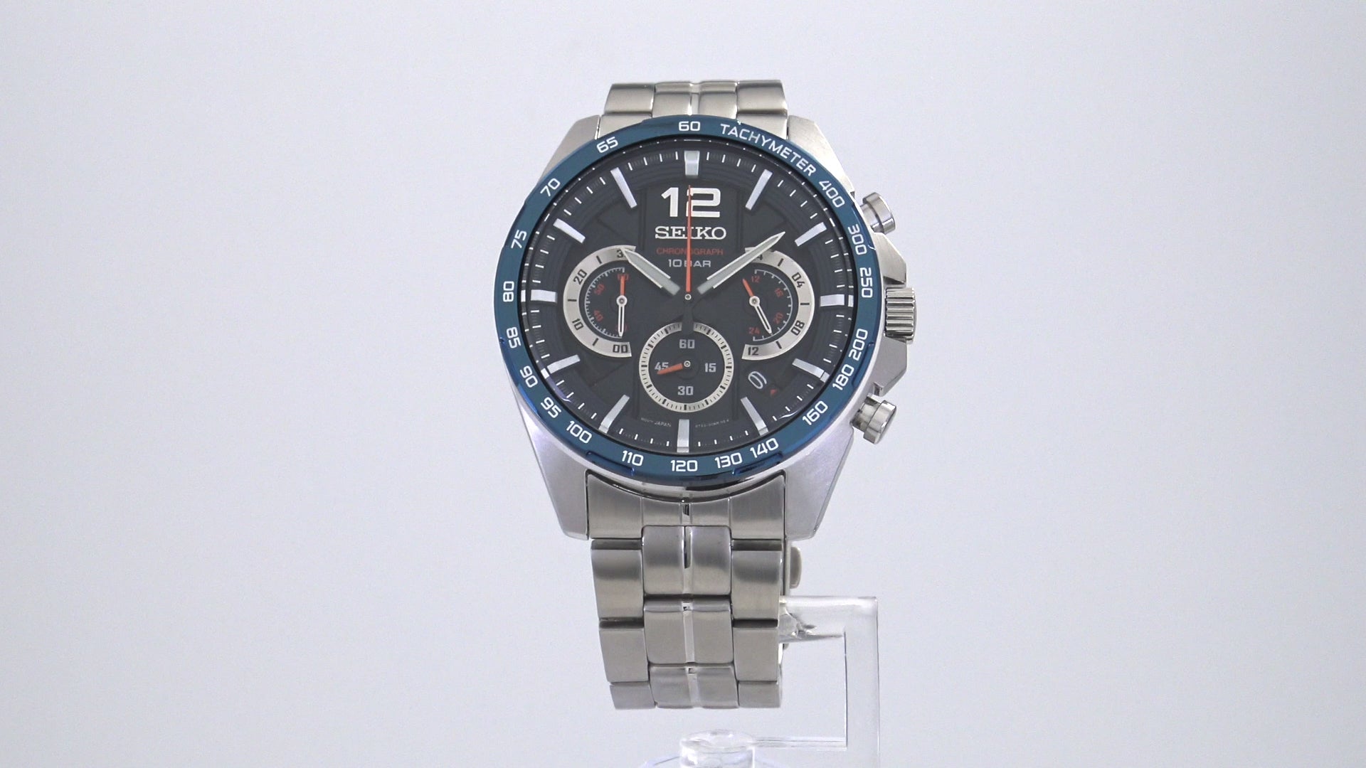 From the Men’s Essential Collection. A perfect blend of precision and design, this dashing chronograph is inspired by racing, hinting at a dashboard in its embossed dial with metallic elements and bright accents. Crafted of stainless steel, with secure screwdown caseback and blue ion-finish tachymeter bezel. The blue multi-layered dial, with orange accents, features LumiBrite hands and 12 o’clock marker, a date calendar and three subdials, one a 24-hour indicator.